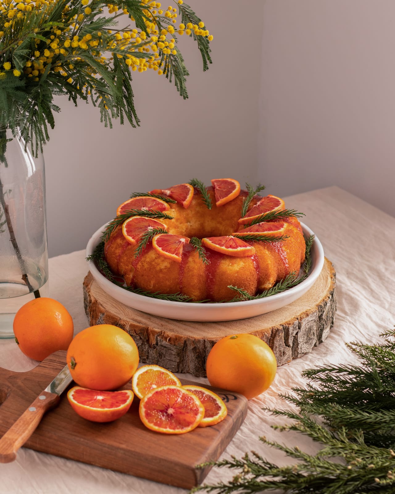 Blood orange bundt cake garnished with citrus slices  on wood board